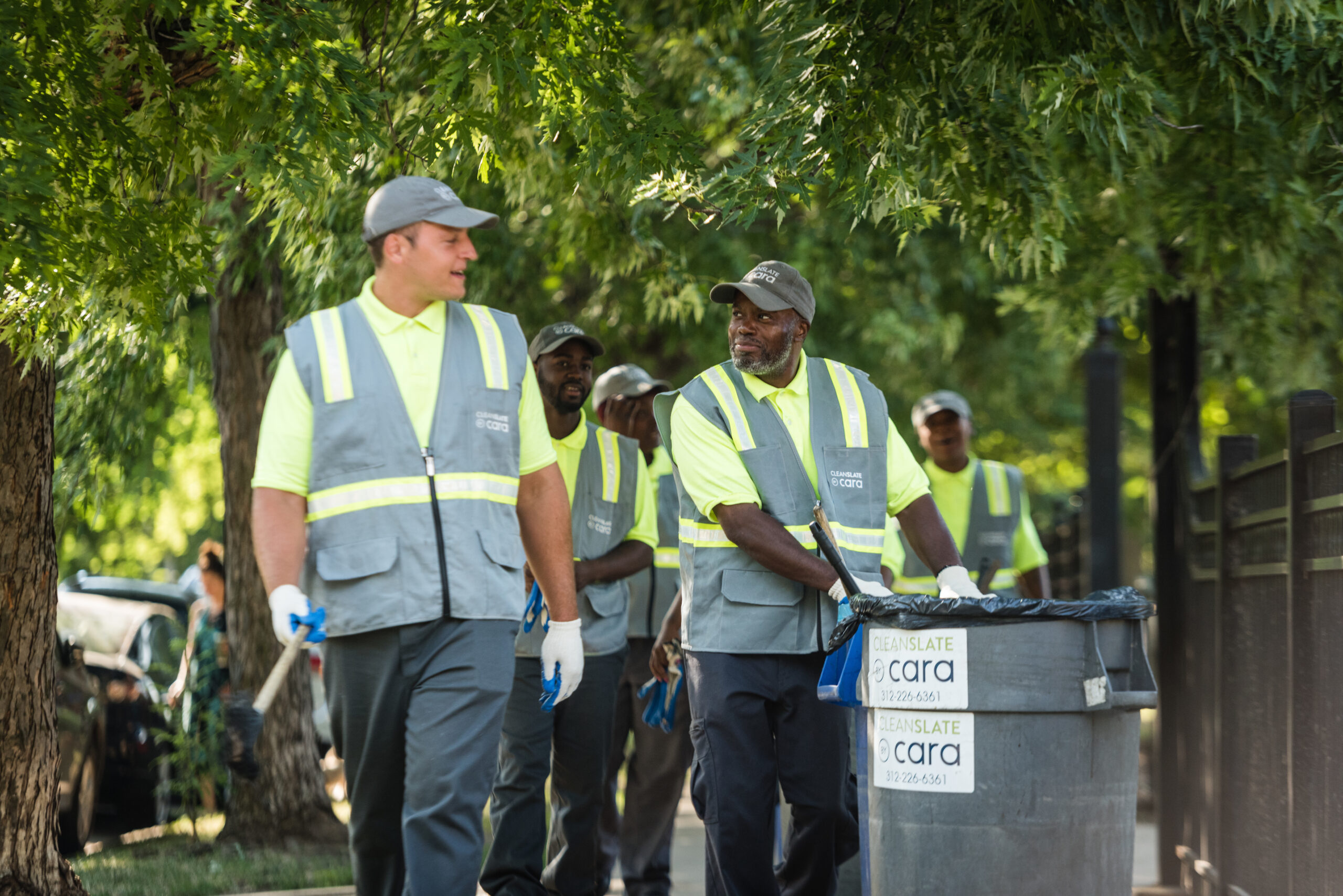 A group of people doing community service and cleaning the sidewalks.
