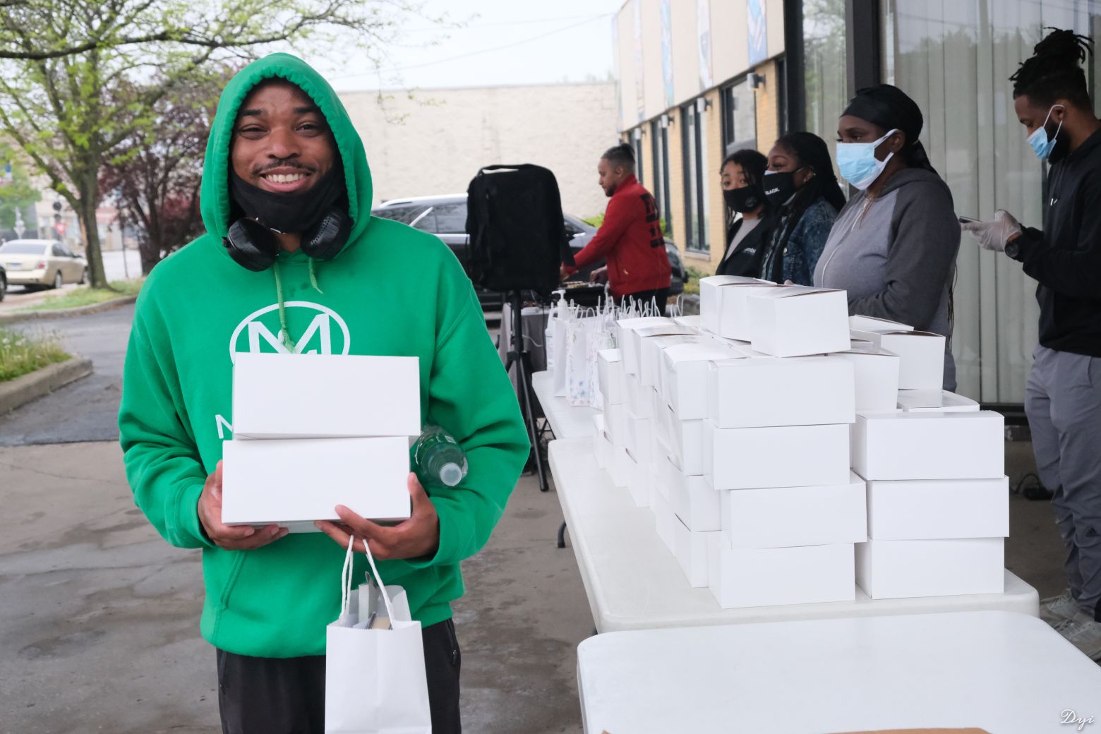 A group of people passing out donations and a person holding the donations they received.