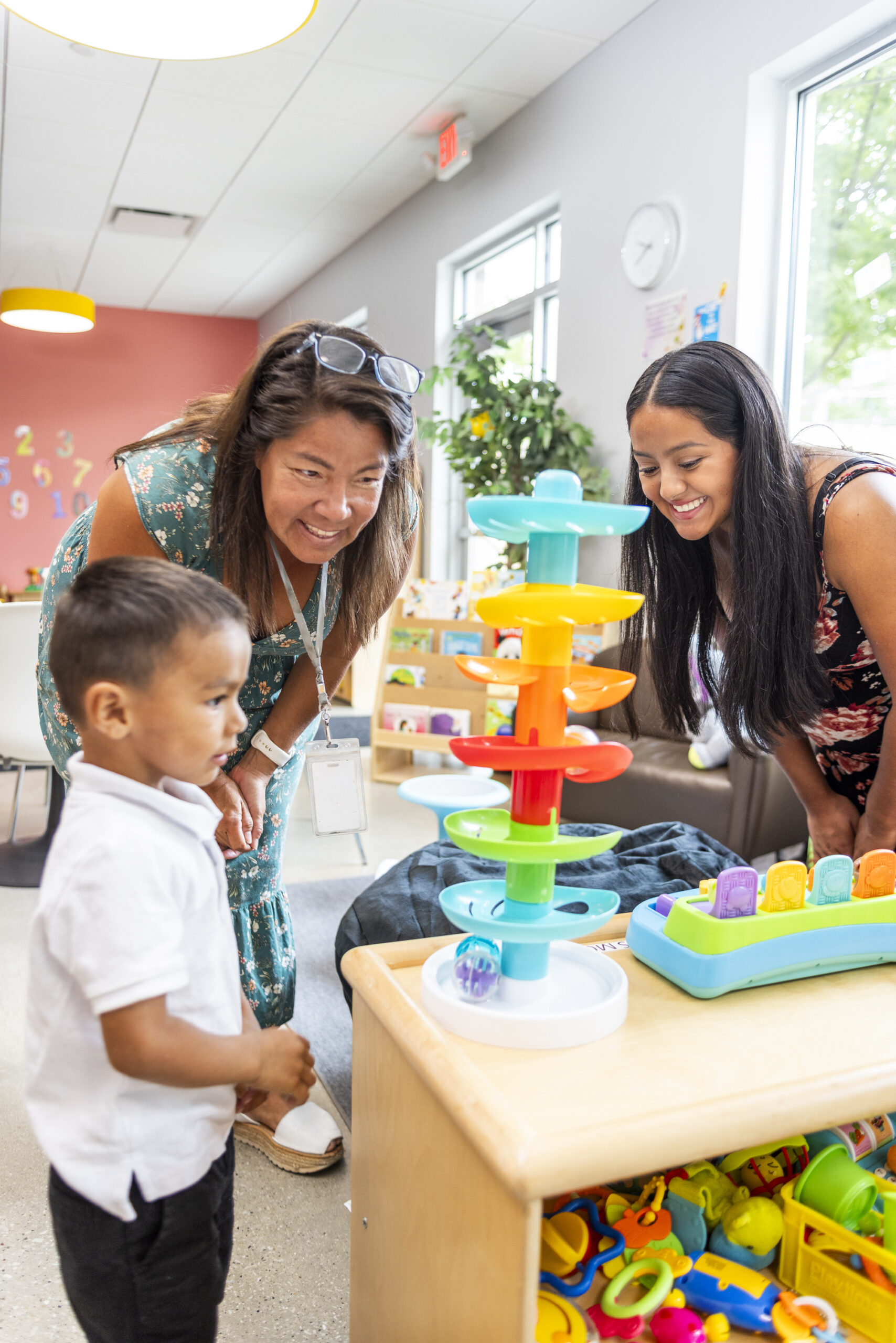 Two teachers helping a child play games.
